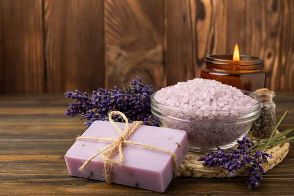 Lavender spa. Sea salt, lavender flowers and handmade soap. Natural herbal cosmetics with lavender flowers on brown texture wood.Spa and relaxation concept.Beauty treatments.Copy space.
