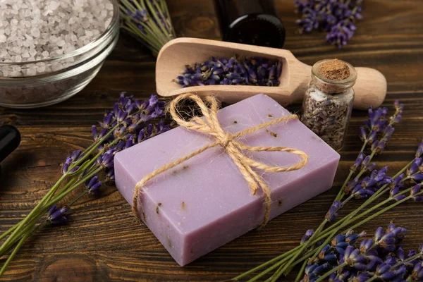 Lavender spa. Sea salt, lavender flowers and handmade soap. Natural herbal cosmetics with lavender flowers on brown texture wood.Spa and relaxation concept.Beauty treatments.Copy space.