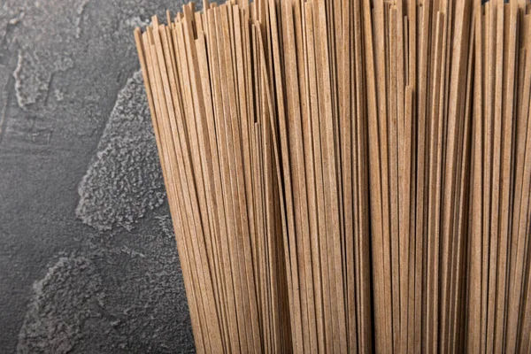 Siyah çimentoyla kaplanmış karabuğday ezmesi. Çiğ erişte. Glütensiz yemek için gerekli malzemeler. Kurutulmuş karabuğday sobalı erişte. Geleneksel Japon yemekleri. Sağlıklı yiyecekler. Kopyalanacak yer.