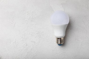 LED lamp energy efficiency concept. Composition on white cement background. Use economical and environmentally friendly light bulb concept.Eco. flat lay.copy space.MOCKUP