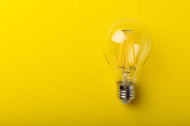 Elektrik ampulleri. Enerji verimliliği kavramı. Sarı arka planda kompozisyon. Ekonomik ve çevre dostu bir ampul kavramı kullan.