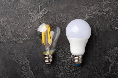 Elektrik ampulleri. Enerji verimliliği kavramı. LED lamba parlak lambaya karşı. Siyah mermer arka planda kompozisyon. Ekonomik ve çevre dostu bir ampul kavramı kullan.