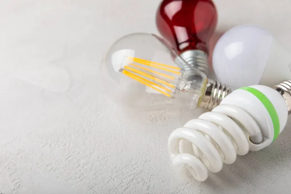 Electric light bulbs. the concept of energy efficiency. LED lamp vs incandescent lamp. Composition on a white cement background. Use an economical and environmentally friendly light bulb concept.