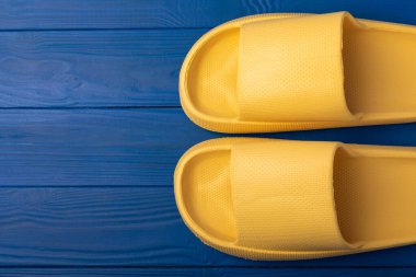 Mavi desenli şık sarı terlikler. Değiştirilebilir ayakkabılar. Plaj ayakkabıları. Metin için yer.