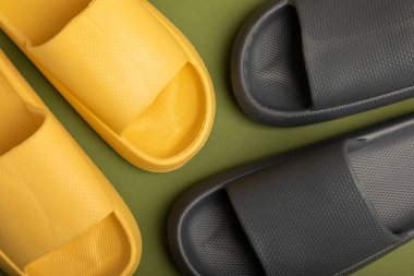 A pair of stylish rubber slippers on a green background.Changeable shoes.Beach shoes.Copy space. Place for text.