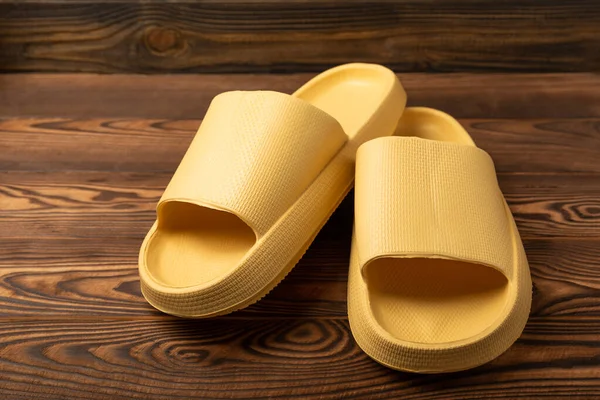 Stylish Rubber Slippers Brown Wooden Background Changeable Shoes Beach Shoes — 스톡 사진