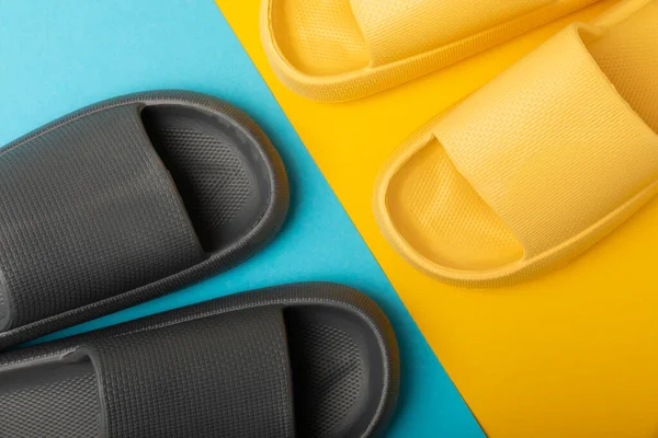 Mavi arka planda bir çift şık lastik terlik. Değiştirilebilir ayakkabılar. Plaj ayakkabıları. Metin için yer.