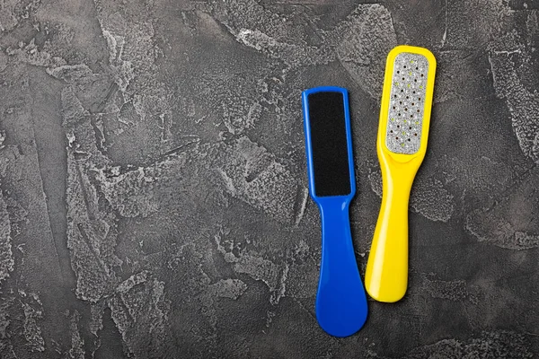 Foot file and grater on black marble background. Foot skin care product. Pumice stone file to remove dead skin from feet. Care and beauty concept. Copy space.