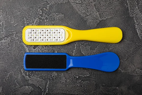 Foot file and grater on black marble background. Foot skin care product. Pumice stone file to remove dead skin from feet. Care and beauty concept. Copy space.