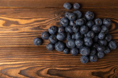 Kahverengi dokuda yabanmersini. Olgun ve taze yaban mersini. Vitaminler. Sağlıklı yiyecekler. Meyve suyu. Uzayı kopyala Metin için yer