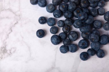 Beyaz mermer arka planda yabanmersini. Olgun ve taze yaban mersini. Vitaminler. Sağlıklı yiyecekler. Meyve suyu. Uzayı kopyala Metin için yer