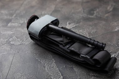 Siyah dokulu arka plandaki kanı durdurmak için tıbbi turnike. Kopyalanacak yer. düz döşek.