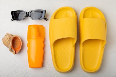 Düz kompozisyon ve beyaz desenli plaj aksesuarları. Plaj terlikleri, güneş gözlüğü ve güneş kremi. Güneş koruması. Kopyalama için yer. Ders için yer..