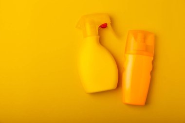 Sarı arka planda güneş kremi. Plastik şişe SPF güneş kremi. Güneş kremi seçimi. Seyahat plajı bezi, pankart. Yaz tatilleri ve cilt bakımı konsepti.