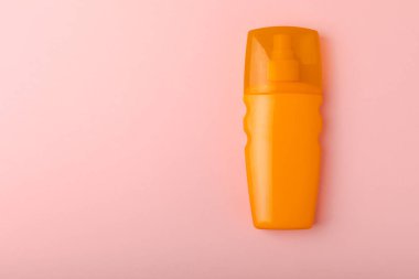 Pembe arka planda güneş kremi. Plastik şişe SPF güneş kremi. Güneş kremi seçimi. Seyahat plajı bezi, pankart. Yaz tatilleri ve cilt bakımı konsepti.