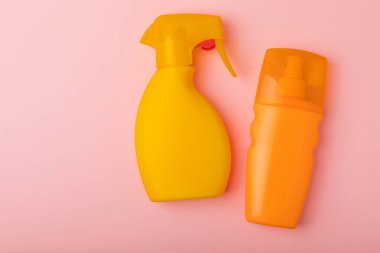 Pembe arka planda güneş kremi. Plastik şişe SPF güneş kremi. Güneş kremi seçimi. Seyahat plajı bezi, pankart. Yaz tatilleri ve cilt bakımı konsepti.