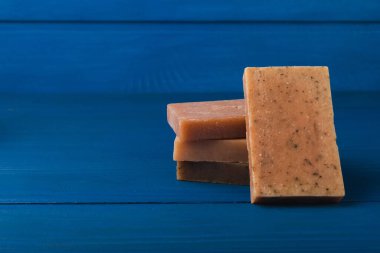 Mavi desenli ahşap üzerinde lavanta çiçekleri olan doğal lavanta sabunu. El yapımı sabun. Temel yağlı kozmetik ürünler. Spa ürünü. Mesaj için yer var. Düz yatıyordu.