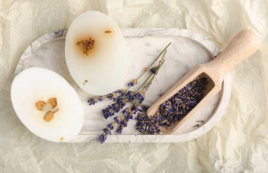 Beyaz çimento üzerine lavanta çiçekli doğal lavanta sabunu. El yapımı sabun. Temel yağlı kozmetik ürünü. Düz yatıyordu.