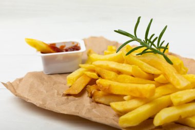 Ahşap arka planda ketçap domates soslu patates kızartması. Fast food. Biberiyeli ev yapımı patates. Zararlı yiyecekler. Mesaj için yer. Boşluğu kopyala.