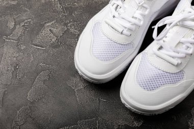 Siyah desenli arka planda beyaz ayakkabılar. Moda. UNISEX. Aktif yaşam tarzı için spor ayakkabıları. Ürün fotoğrafı ve kaldırma konsepti. Sokak stili. Metin için yer..