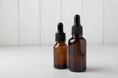Essential oil in a glass bottle with a pipette. Bottle with fragrant oil on a white wooden background. essential oil mockup with copy space. serum.