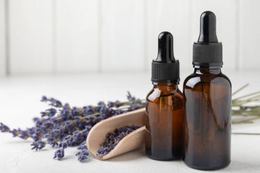 Essential oil of lavender on a white texture background. Spa concept. RELAX. Bottle with fragrant oil and lavender flowers.Aromatic oil with lavender scent.mockup of lavender essential oil.Copy space.