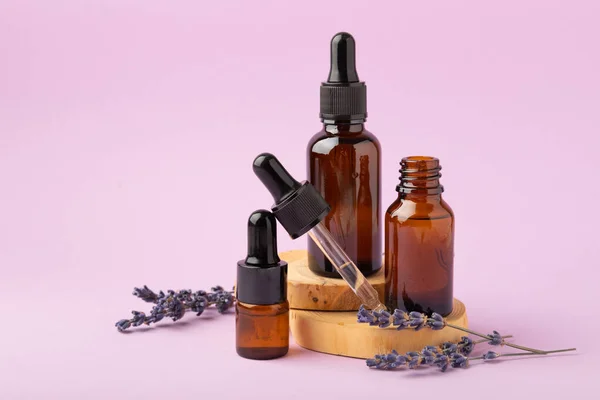 Essential oil of lavender on a lilac background. Spa concept. RELAX. Bottle with fragrant oil and lavender flowers.Aromatic oil with lavender scent.mockup of lavender essential oil.Copy space. Place for text.