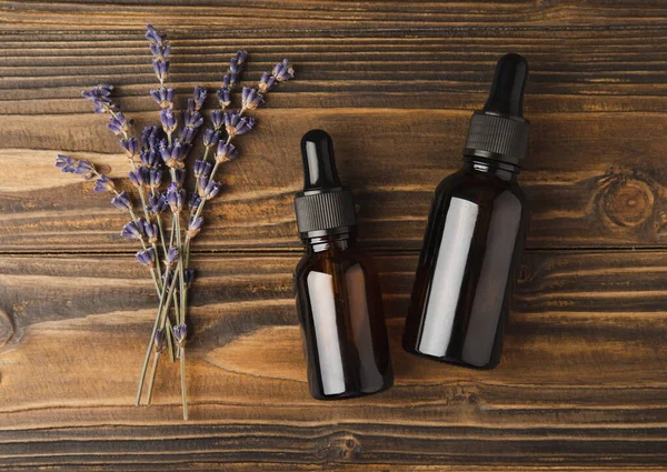 Essential oil of lavender on a brown background. Spa concept. RELAX. Bottle with fragrant oil and lavender flowers.Aromatic oil with lavender scent.mockup of lavender essential oil.Copy space. Place for text.