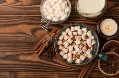 Kahverengi dokuma masasında kış içecekleri için marşmelovlar ve marşmelovlar. Kış içeceği. Marshmallow ve baharatlı sıcak çikolata..