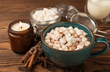 Kahverengi dokuma masasında kış içecekleri için marşmelovlar ve marşmelovlar. Kış içeceği. Marshmallow ve baharatlı sıcak çikolata..