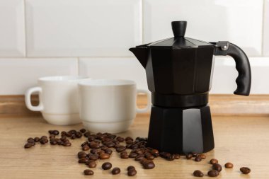 Metal coffee maker in the kitchen. Geyser coffee maker with coffee cups on the background of a brown table.Concept morning.Morning coffee. Place to copy. Place for text.