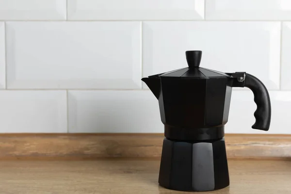 Metal coffee maker on the kitchen table. Geyser coffee maker on brown texture background. Morning concept. Morning coffee.Space for copy. Place for text.