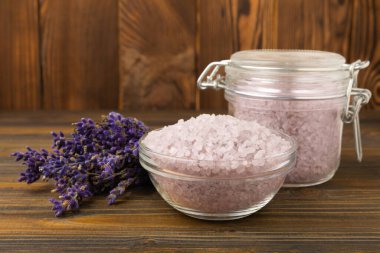 Lavender spa. Sea salt, lavender flowers, essential oils, body cream and handmade soap. Natural herbal cosmetics with lavender flowers on brown texture background. Relax and spa concept. Space for text.