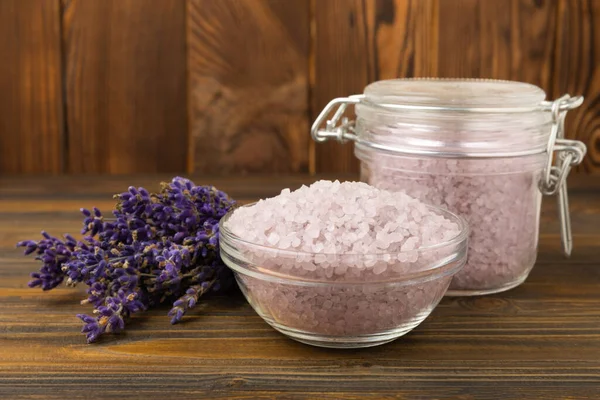 Lavender spa. Sea salt, lavender flowers, essential oils, body cream and handmade soap. Natural herbal cosmetics with lavender flowers on brown texture background. Relax and spa concept. Space for text.