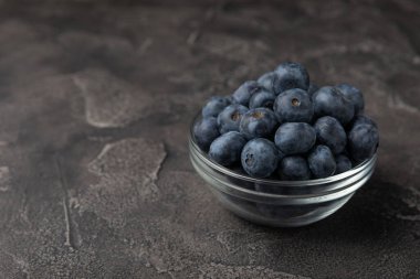 Siyah desenli arka planda seramik bir kasede yaban mersini. Olgun ve taze yaban mersini. Vitaminler. Sağlıklı yiyecekler. Sulu böğürtlen. Boşluğu kopyala. Mesaj için yer