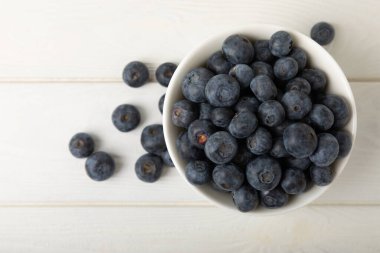 Blueberries in a bowl on white textured background. Ripe and fresh blueberries. Vitamins. Healthy food. Juicy berry.Copy space.Place for text