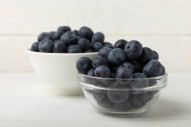 Blueberries in a bowl on white textured background. Ripe and fresh blueberries. Vitamins. Healthy food. Juicy berry.Copy space.Place for text