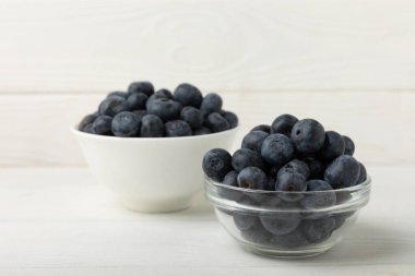 Blueberries in a bowl on white textured background. Ripe and fresh blueberries. Vitamins. Healthy food. Juicy berry.Copy space.Place for text
