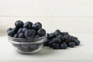 Blueberries in a bowl on white textured background. Ripe and fresh blueberries. Vitamins. Healthy food. Juicy berry.Copy space.Place for text
