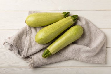 Squash vegetable marrow zucchini with kitchen towel on white texture background.Vegetarian organic vegetables.Healthy food.Copy space.Place for text.Healthy food concept.