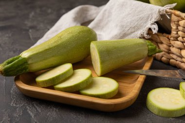 Zucchini slices.Squash vegetable marrow zucchini on black texture background.Vegetarian organic vegetables.Healthy food.Copy space.Place for text.Healthy food concept.