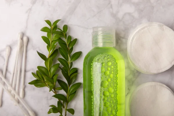 Micellar cleansing water and makeup remover pads. Skin cleansing from sebium and make-up. Composition on a white marble background. Beauty concept. Copy space text. Flat lay