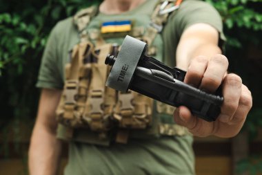 Bir asker, ilk yardımda kanı durdurmak ve kanamayı önlemek için elinde tıbbi bir turnike tutuyor. Savaş taktik ekipmanları. Savaş kullanımı Turnstil.