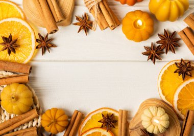 Autumn composition.Pumpkin candles,spicy star anise spices and cinnamon on a white wooden background.Cozy home decor.Halloween concept.Happy Thanksgiving.Flat lay.Copy space.