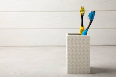 Toothbrush in a glass on a light background with copy space and place for text. Flat lay. Oral hygiene. Oral care set. Dentist concept.