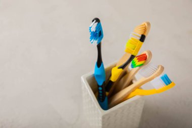 Toothbrush in a glass on a light background with copy space and place for text. Flat lay. Oral hygiene. Oral care set. Dentist concept.