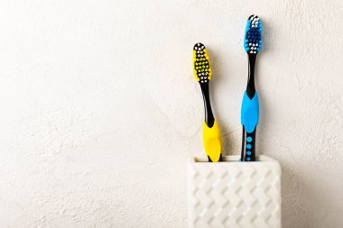 Toothbrush in a glass on a light background with copy space and place for text. Flat lay. Oral hygiene. Oral care set. Dentist concept.