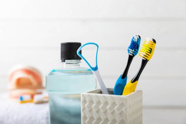 Toothbrush in a glass on a light background with copy space and place for text. Flat lay. Oral hygiene. Oral care set. Dentist concept.