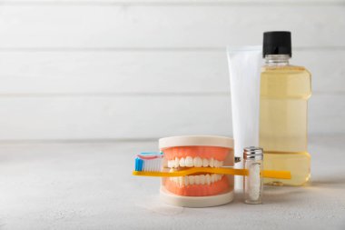 Dentures with a toothbrush on a white background. Upper and lower jaws with false teeth. Dentures or false teeth, close-up. copy space.MOCKUP