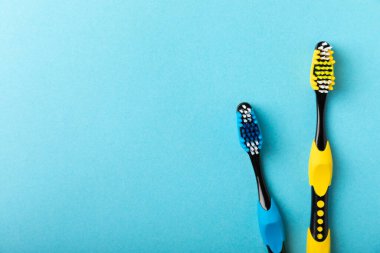 Toothbrushes. Oral care. Dental care. Composition with different toothbrushes on a blue background. Teeth love concept.Copy space. Place for text.Fletley